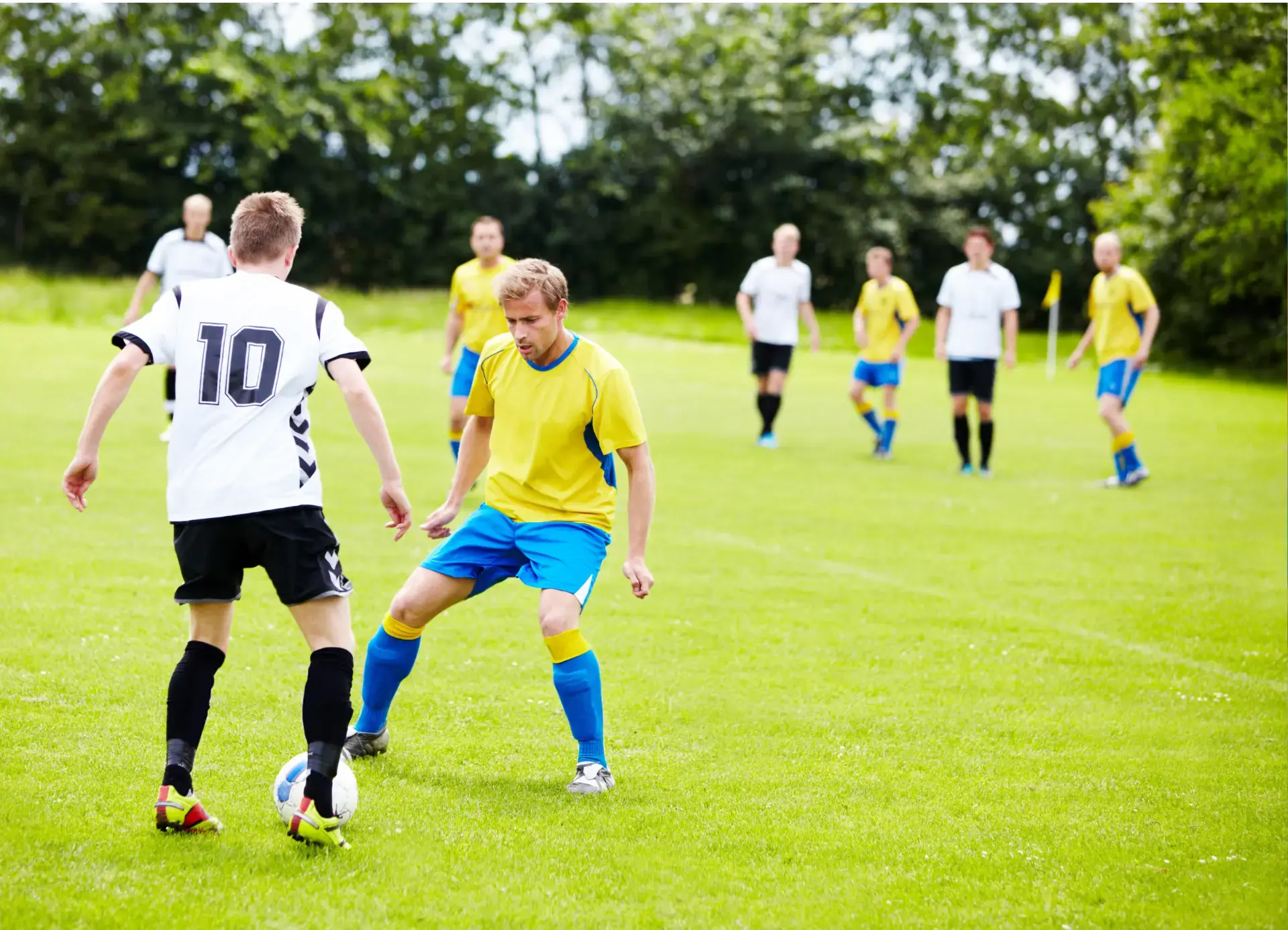 Céges csapatépítő sportnap focimeccsel zöld természetes füves pályán csapatokban