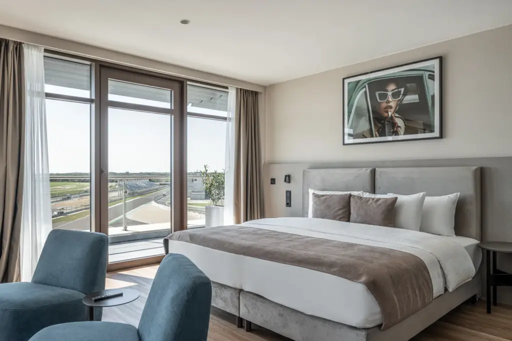 Modern hotelszoba king size ággal és motorsport pálya kilátással