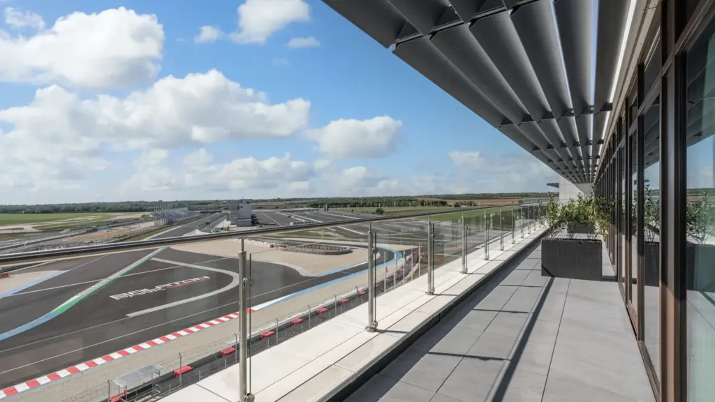 Hotel terasz üvegkorláttal és közvetlen motorsport pálya panorámával