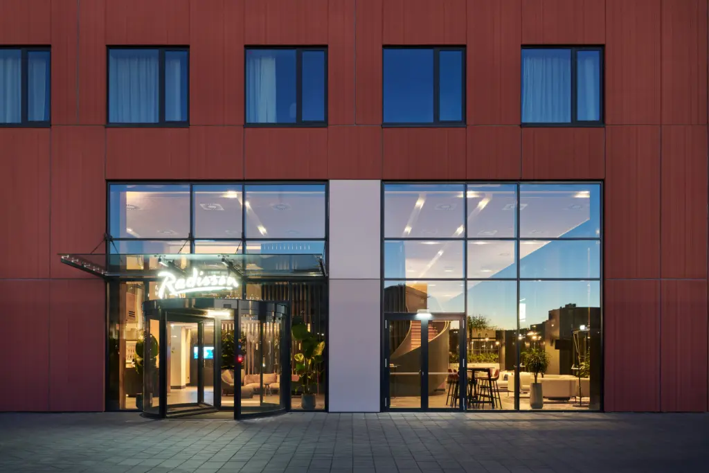 Radisson Hotel Budapest BudaPart bejárat modern homlokzattal és üvegfalú lobby-val Újbudán