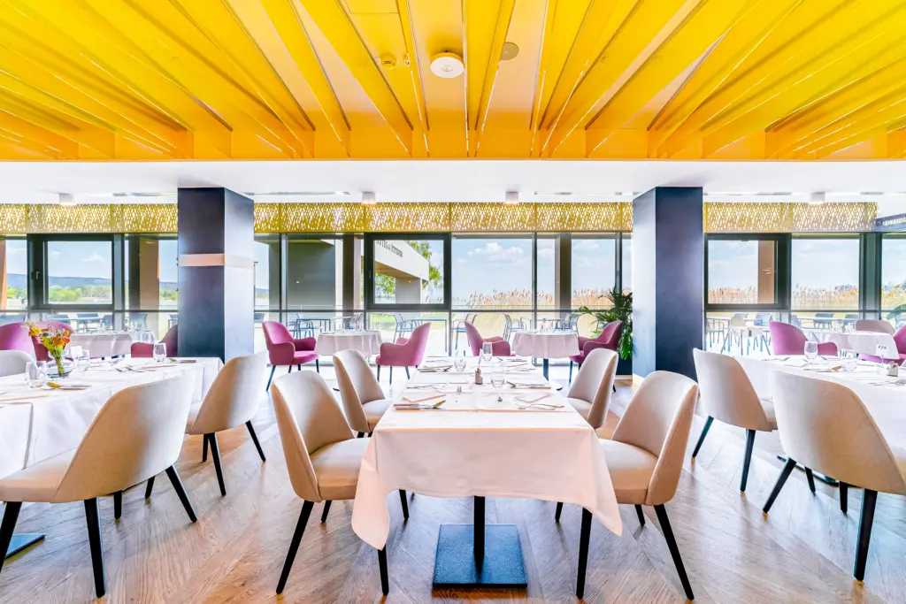 Hotel étterem sárga mennyezettel, Balaton panorámával és modern székekkel