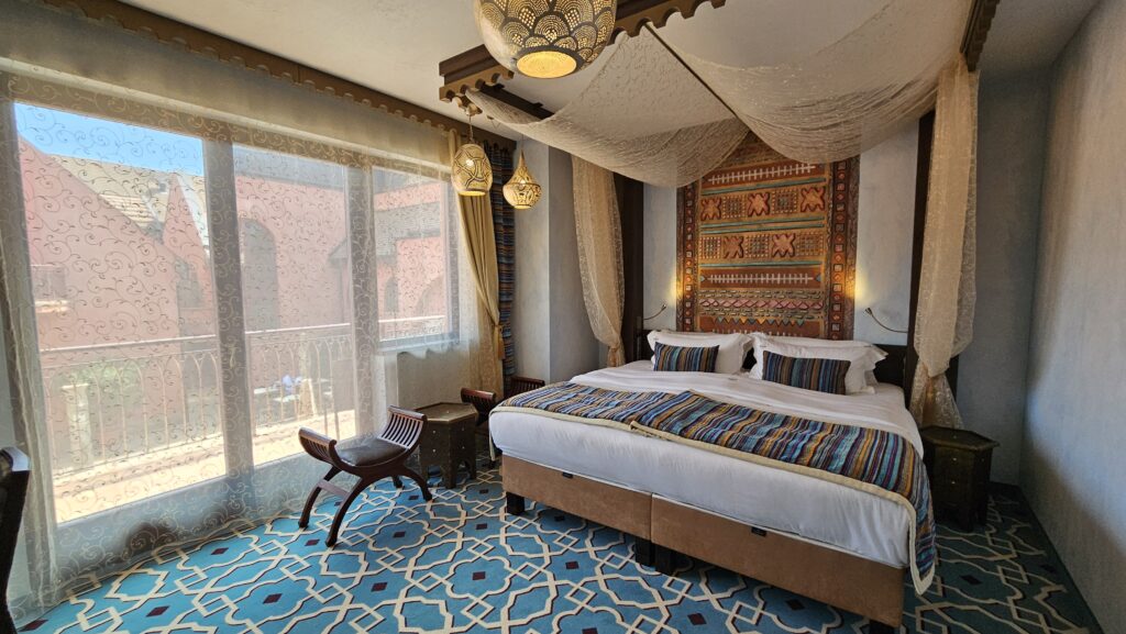 A Mesés Shiraz Hotel egyik marokkói tematikájú szobája baldachinos ággyal, autentikus keleti textíliákkal és színes mozaik padlóval. Az arab világ misztikus hangulata, modern komfort és erkélyes elhelyezés Egerszalókon.