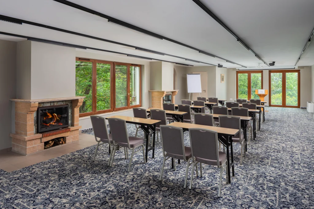 A Silvanus Hotel Visegrád konferenciaterme iskolapados elrendezéssel, ahol kandalló és természetes fény árasztja el a teret erdőre néző ablakokkal