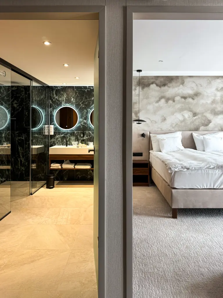 A Silvanus Hotel Visegrád superior szobája design fürdőszobával, ahol márvány falak és illuminált tükrök láthatók