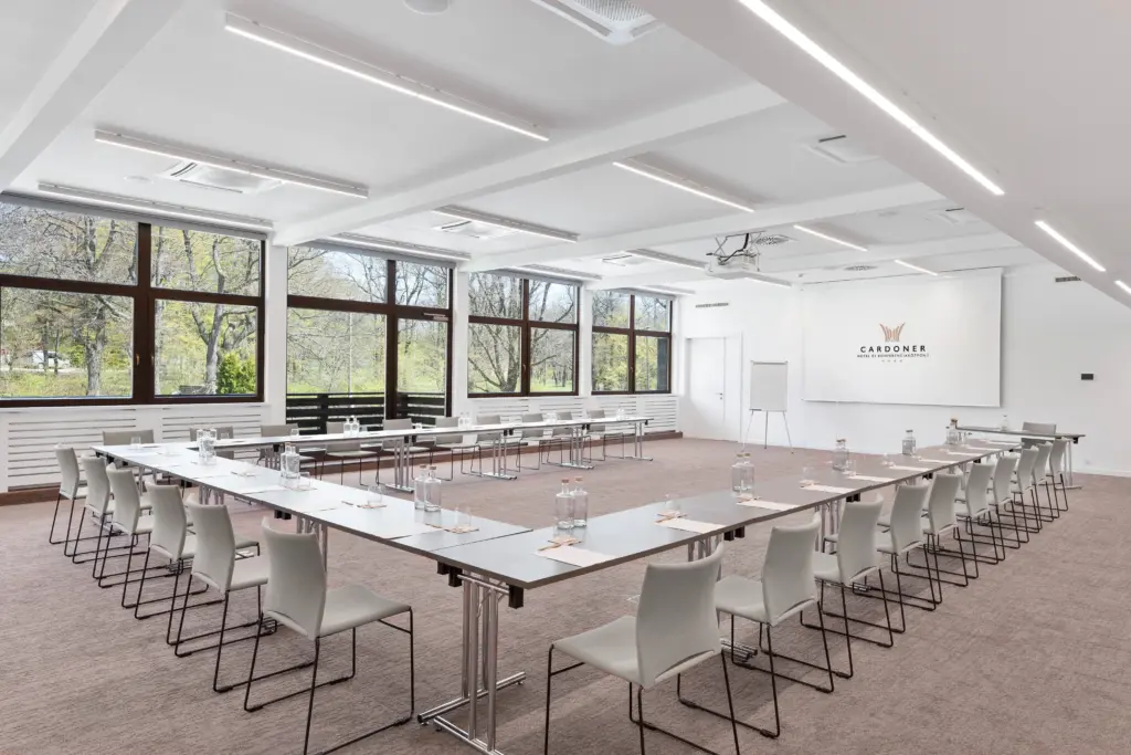 A Cardoner Hotel Dobogókő konferenciaterme U alakú ültetéssel, ahol 150 fő vesz részt meetingen természetes fényben, erdőre néző ablakokkal