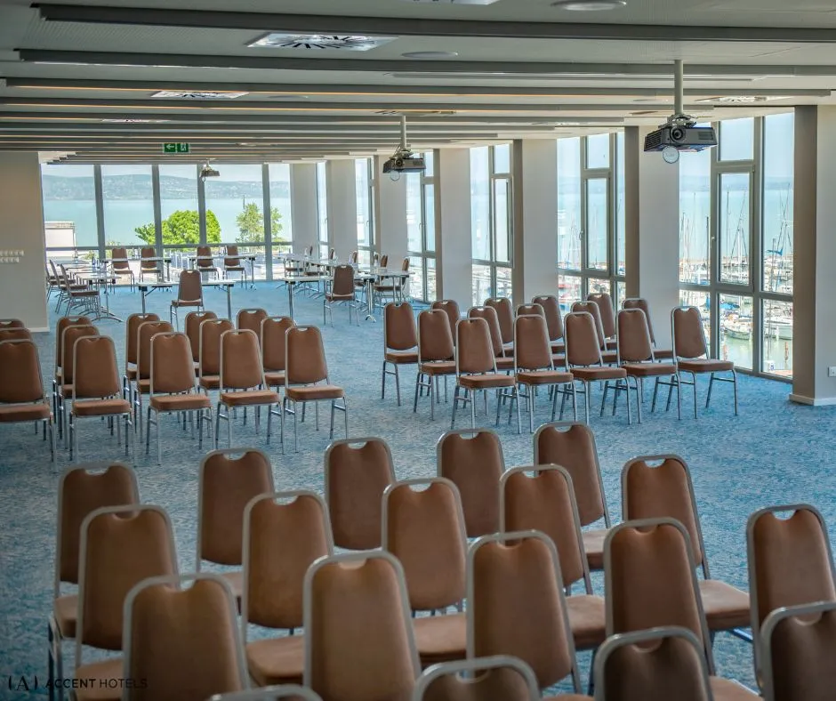 A Hotel Yacht Siófok konferenciaterme színházi ültetéssel, ahol panorámaablakokon keresztül a Balaton és a vitorláskikötő látható